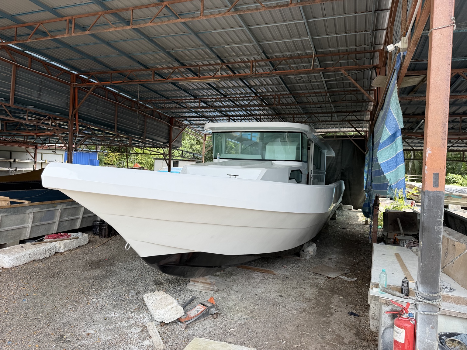 Completed white enclosed vessel viewed from the bow in the LUXMARINE boatyard